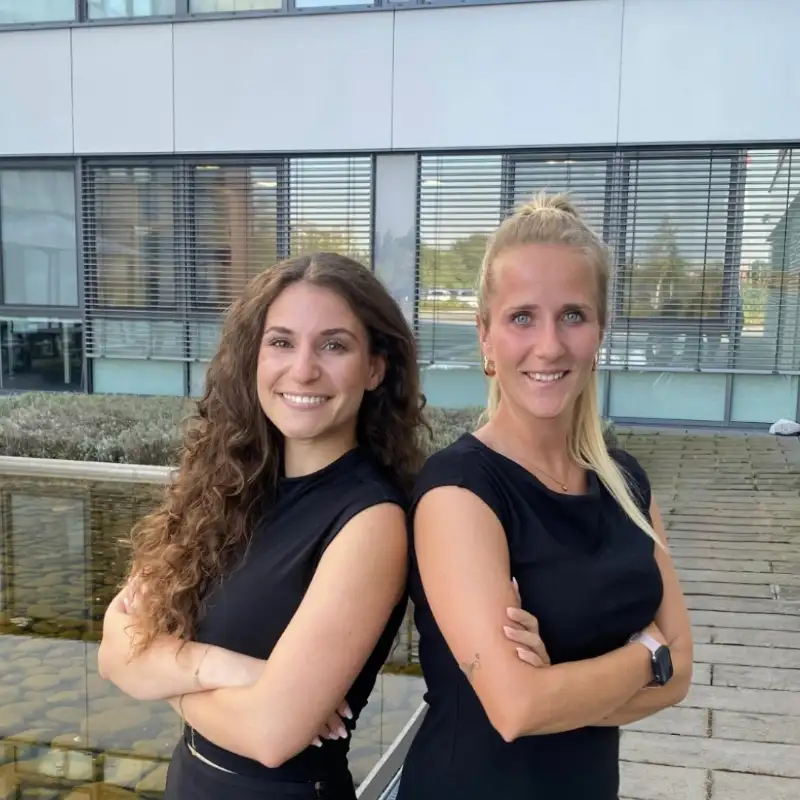 Fabienne Delp und Selina Rettig, Mitarbeiterinnen bei Transgourmet stehen auf dem Hof vor ihrem Bürogebäude. Fabienne Delp und Selina Rettig, Mitarbeiterinnen bei Transgourmet stehen auf dem Hof vor ihrem Bürogebäude.